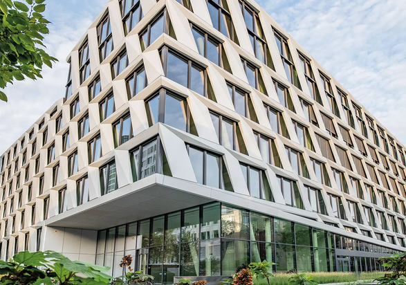Modern office building architecture of the ONE PLAZA project with a distinctive façade and large glass surfaces.